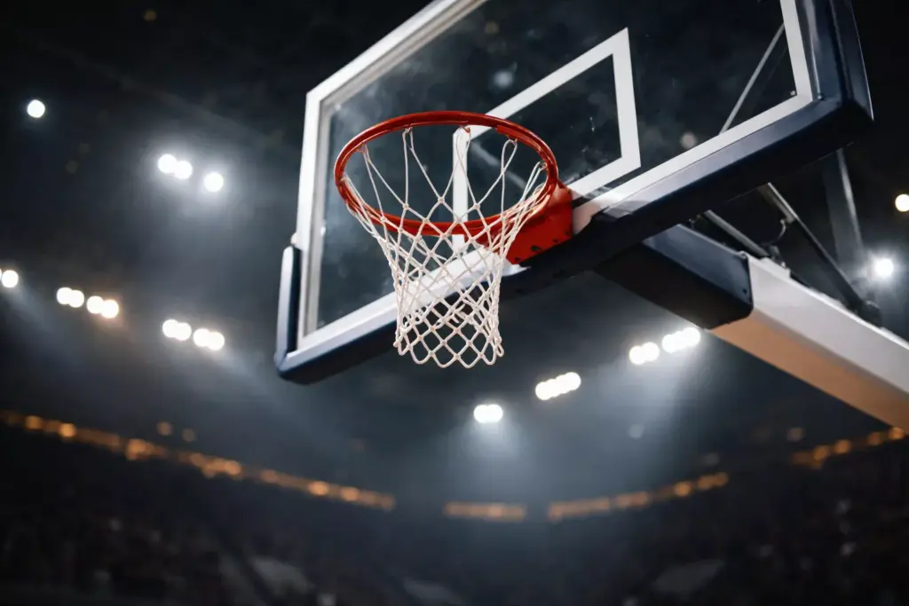 Canasta de baloncesto profesional con red y tablero en pabellón deportivo