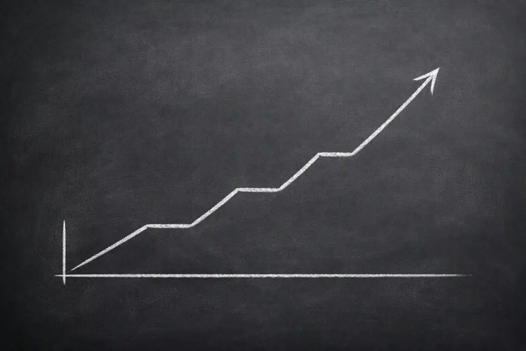 Gráfico de línea ascendente dibujado en una pizarra con tiza blanca