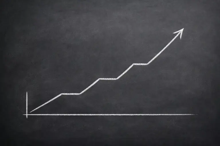 Gráfico de línea ascendente dibujado en una pizarra con tiza blanca